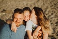 kiss. happy family on beach. mom, dad and daughter on vacation at seaside resort Royalty Free Stock Photo