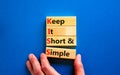 KISS keep it short and simple symbol. Concept words KISS keep it short and simple wooden blocks. Beautiful blue table, blue