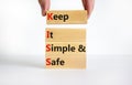 KISS keep it simple and safe symbol. Concept words KISS keep it simple and safe wooden blocks. Beautiful white table, white