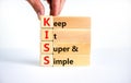 KISS keep it super and simple symbol. Concept words KISS keep it super and simple wooden blocks. Beautiful white table, white