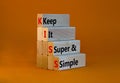 KISS keep it super and simple symbol. Concept words KISS keep it super and simple wooden blocks. Beautiful orange table, orange