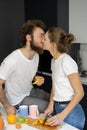 Kissing beautiful couple embracing each other enjoying their their morning coffee in a new house. Making fun at modern Royalty Free Stock Photo