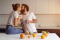 Kissing beautiful couple embracing each other enjoying their their morning coffee in a new house. Making fun at modern Royalty Free Stock Photo