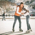 Kissing couple, girls and boy ice skating outdoor at rink Royalty Free Stock Photo