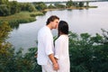 Kissing couple on the river background near the foliage