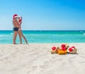 Kissing lovers couple in santa hats at sea beach Royalty Free Stock Photo
