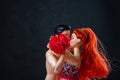 Kissing man and woman doll with red flowers.