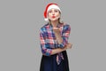 Kissing you! Portrait of kindly beautiful adult woman in red santa cap and checkered shirt standing and sending you air kiss, Royalty Free Stock Photo