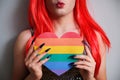 Kissy face unrecognizable transgender person holding a rainbow flag heart. Royalty Free Stock Photo