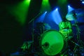 A kit of drums and a microphones on an empty stage