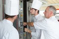 Kitchen apprentices learnig to use oven Royalty Free Stock Photo