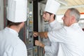 Kitchen apprentices learnig to use oven