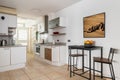 Kitchen area with units and high table to eat in apartment