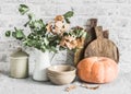 Kitchen autumn still life. Dishes, cutting boards, pumpkin on the table, on a light background. Rustic cozy style Royalty Free Stock Photo