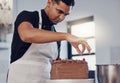 Kitchen, baking and man decorating cake with chocolate sprinkles and frosting with focus and skill. Sweets, small Royalty Free Stock Photo
