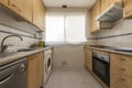 Kitchen with beech wood furniture, pink granite countertop and window Royalty Free Stock Photo