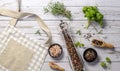 Kitchen beige apron, wooden spoon with spices, pepper mill, wood kitchen utensils on a wooden background. Top view