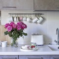 Kitchen in beige tones. Toaster. Mugs and milk jugs hang on hooks. Sink with taps. tray with a mug and marshmallows Royalty Free Stock Photo