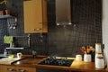 Kitchen with Black Tiles, Natural Wood Worktop, Stove Royalty Free Stock Photo