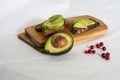 On the kitchen board half an avocado and slices on bread, avocado sandwich Royalty Free Stock Photo