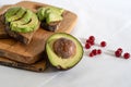 On the kitchen board half an avocado and slices on bread, avocado sandwich Royalty Free Stock Photo