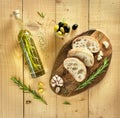 Kitchen chopping board with sliced fresh ciabatta, sprigs of rosemary, garlic, green and black olives. Bottle of olive Royalty Free Stock Photo