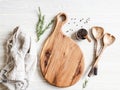 Kitchen cooking flat lay. Spices, wood spoons and wood cutting board for placing your text on a light wood background. Top view.