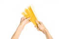 The kitchen and the cooking theme: man's hand holding a stack of raw spaghetti on an isolated white background in studio