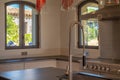 Kitchen corner with a large stainless steel faucet, a steel gas stove, and white furniture