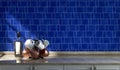 Kitchen counter with coffee mugs and copper hammered cups on it with blue alternating ceramic tiled wall, under morning sunshine,