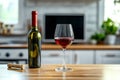 On the kitchen countertop, a bottle sits in the background as a red wine glass is illuminated by soft sunlight Royalty Free Stock Photo