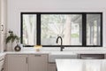 A kitchen detail with brown cabinets and a black faucet on a farmhouse sink. Royalty Free Stock Photo