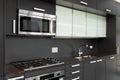 A kitchen detail with dark grey cabinets and stainless steel appliances. Royalty Free Stock Photo