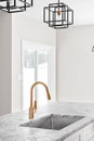 Kitchen detail shot with a gold faucet and modern lights. Royalty Free Stock Photo