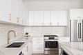 A kitchen detail with white cabinets and a brown picket tile backsplash. Royalty Free Stock Photo