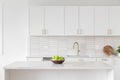 A kitchen detail with white cabinets, gold faucet, and tiled backsplash. Royalty Free Stock Photo