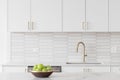 A kitchen detail with white cabinets, gold faucet, and tiled backsplash. Royalty Free Stock Photo