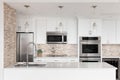 A kitchen detail with white cabinets and a stone and glass tile backsplash. Royalty Free Stock Photo