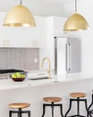 A kitchen detail of a white kitchen with gold lights and faucet. Royalty Free Stock Photo