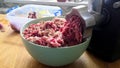 Kitchen electric meat grinder shreds meat into strips of minced meat. Unmodified camera color.