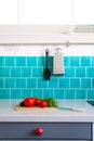 Kitchen features dark gray flat front cabinets paired with white quartz countertops and a glossy blue care tile. Royalty Free Stock Photo