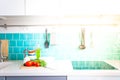 Kitchen features dark gray flat front cabinets paired with white quartz countertops and a glossy blue care tile. Royalty Free Stock Photo