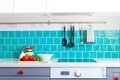 Kitchen features dark gray flat front cabinets paired with white quartz countertops and a glossy blue care tile. Royalty Free Stock Photo