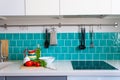 Kitchen features dark gray flat front cabinets paired with white quartz countertops and a glossy blue care tile. Royalty Free Stock Photo