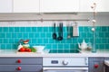 Kitchen features dark gray flat front cabinets paired with white quartz countertops and a glossy blue care tile. Royalty Free Stock Photo