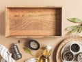 Kitchen flat lay with wood tray for culinary text and small bowls various dry spices and olive oil in glass bottle on beige