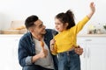 Kitchen Fun. Cheerful young arab dad and his little daughter singing at home Royalty Free Stock Photo