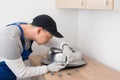 Kitchen furniture assembly worker inserts fixtures into the sink to secure it