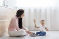 Little boy drumming on metal saucepan, sitting with mom Royalty Free Stock Photo