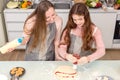 In the kitchen at home, a playful mother and daughter yell while making pizza dough